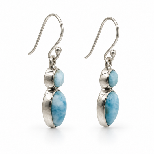 Side view of two-stone Larimar earrings showing round and downward teardrop cabochons in polished silver settings.