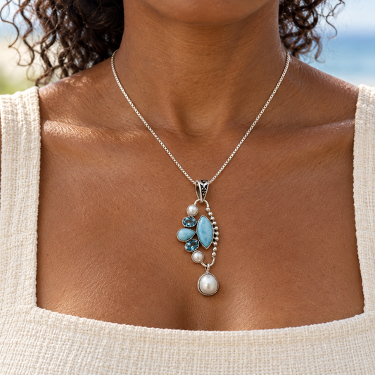 Dark-complexioned woman wearing 0.8 by 1.9 inch Larimar and pearl sterling silver necklace