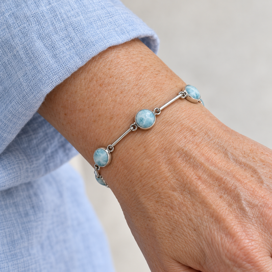 Larimar round-stone sterling silver bar-link bracelet on a model wrist with a pale-blue sleeve.