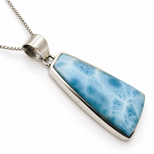 Natural Larimar trapezoid pendant in sterling silver, left angled view on glossy white