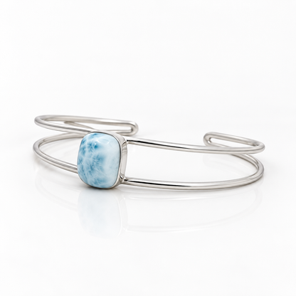 Cushion-shaped Larimar sterling silver double-wire cuff bracelet, left angled view on glossy white