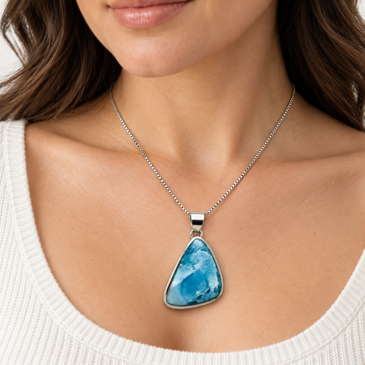 Woman wearing an asymmetric triangular Larimar necklace shown at 1.1 inches wide by 1.7 inches high