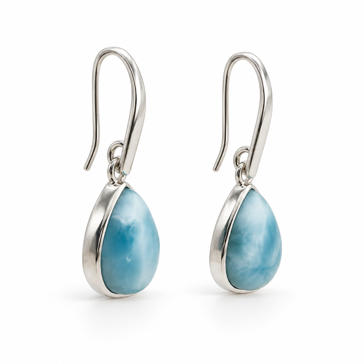 Side view of pear-shaped Larimar earrings showing silver bezel depth and tapered earwires on white.