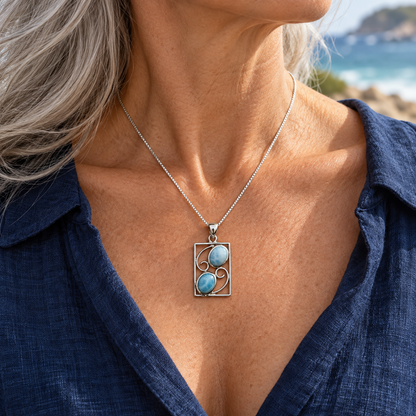 Two-stone rectangular Larimar necklace worn by a silver-haired woman in navy