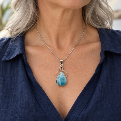 Silver-haired woman in navy linen wearing Larimar Ocean Embrace necklace