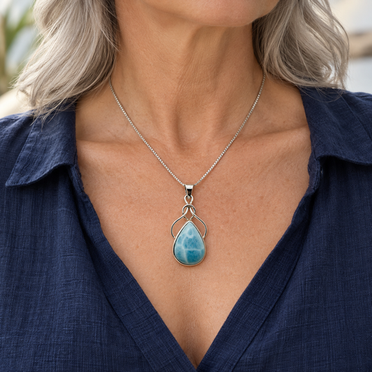 Silver-haired woman in navy linen wearing Larimar Ocean Embrace necklace