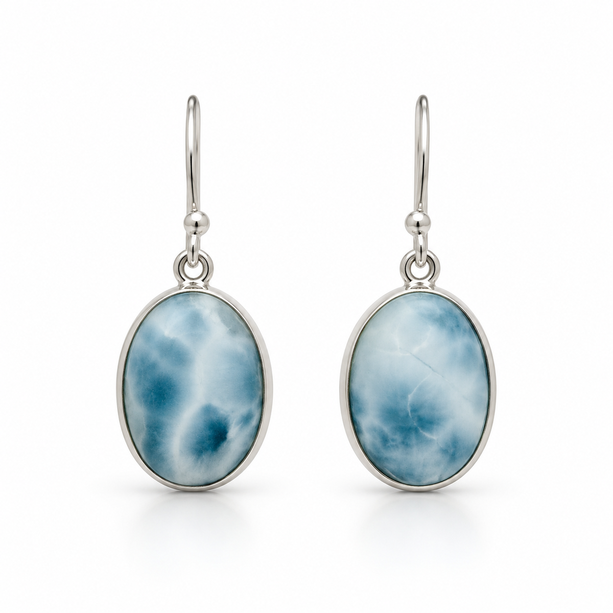 Front view of oval blue and white Larimar earrings in plain silver bezels on white.