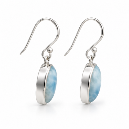 Side view of oval Larimar earrings with polished silver bezel sidewalls and photographer reflections removed.