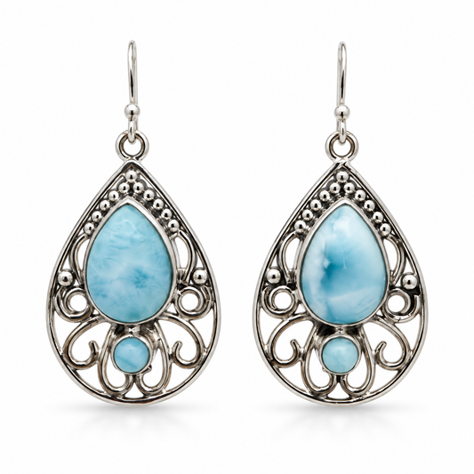 Front view of teardrop Larimar earrings with round Larimar accents and open silver scrollwork on white.
