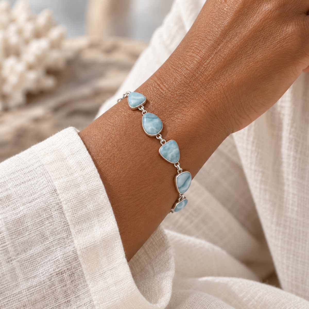 Freeform Larimar sterling silver bracelet worn on a model wrist with an ivory linen sleeve.