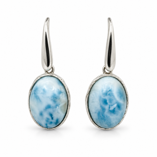 Front view of oval Larimar earrings with tapered silver earwires and textured rims on white.